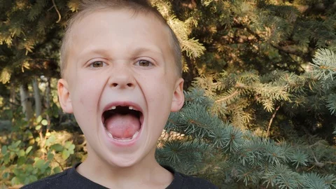 Happy boy pulls out his front tooth and smiles big.  Video stock 94561650