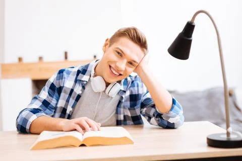 Happy boy reading a book at the table Stock Photos