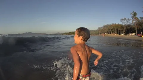 Happy boy running and jumping fast into the sea water Stock Footage 76861553