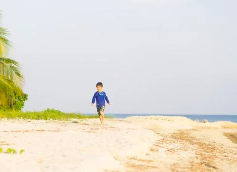 Happy boy running on the beach Stock Photos