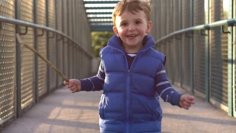 Happy Boy running on the bridge towards camera in slow motion Stock Footage 74840715
