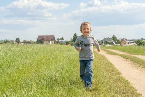 Happy boy running on the field Stock Photos