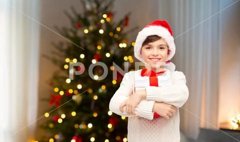 Happy boy in santa hat with gift box on christmas Stock Photos