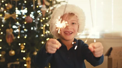 Happy boy in santa hat playing with sparklers 스톡 동영상 346969873