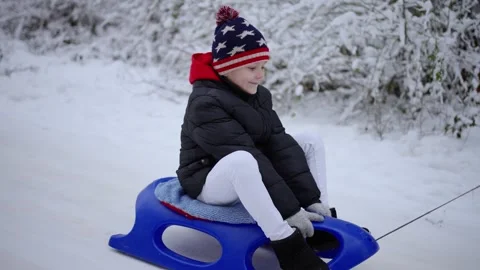 A happy boy is sledding in the snow Stock Footage 258301767