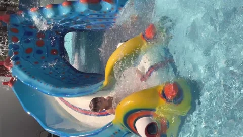 Happy boy is sliding down the water slide at aqua park. Stock Footage 158233154
