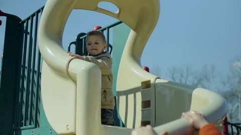 Happy boy sliding upside down in playground. 4k Stock-Footage 87486973