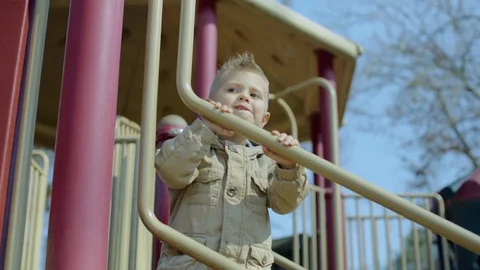 Happy boy sliding upside down in playground. 4k Video stock 87489260