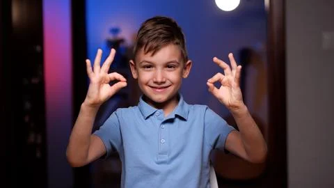 Happy boy smiling and gesturing ok sign with both hands Stock Photos