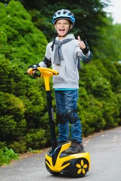 Happy boy standing on hoverboard or gyroscooter outdoor Stock Photos