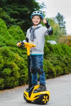 Happy boy standing on hoverboard or gyroscooter outdoor Stock Photos