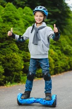 Happy boy standing on hoverboard or gyroscooter outdoor Stock Photos