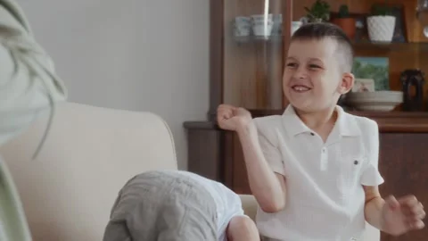 Happy boy throwing pillow during cheerful family game at home with laughter Stock Footage 315749029