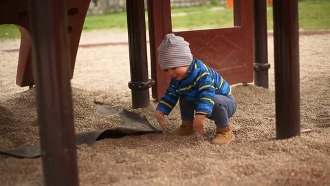 Happy boy touching sand and playing on the playground Stock Footage 75215825