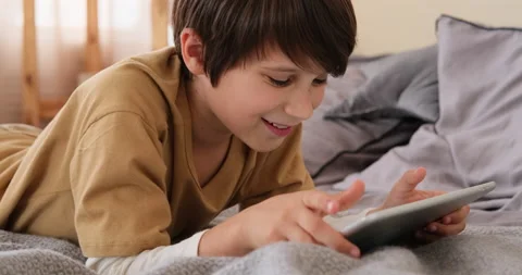 Happy boy using digital tablet on bed Stock Footage 145236206