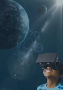 Happy boy in VR headset looking to 3D planet against blue background with Stock Photos