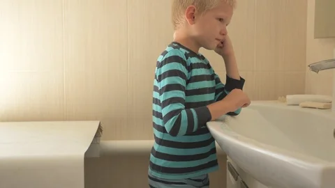 Happy boy washes his hands with soap and brushes his teeth in bathroom. Child Stock Footage 93534231
