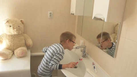 Happy boy washes his hands with soap and brushes his teeth in bathroom. Child Stock Footage 93534346