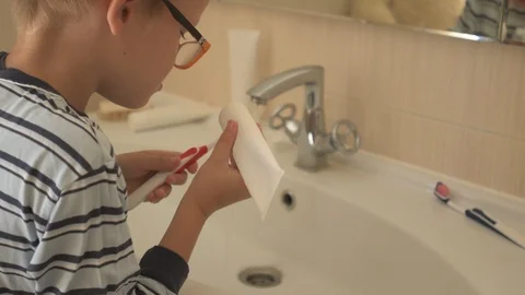 Happy boy washes his hands with soap and brushes his teeth in bathroom. Child Stock Footage 93534433