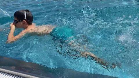 Happy boy wearing goggles holding swimming pool edge and diving. Stock Footage 342030459
