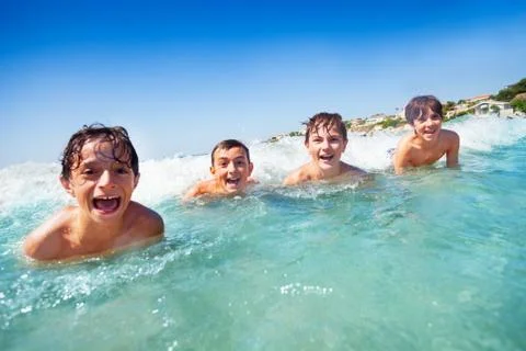 Happy boys having fun while swimming in the sea Stock Photos
