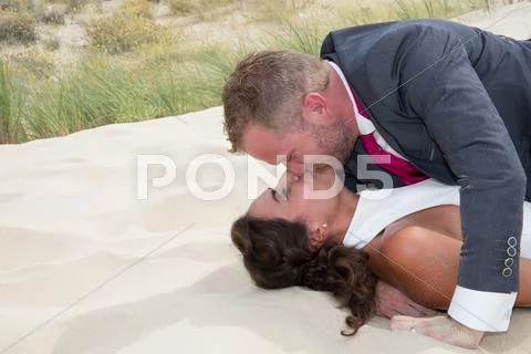 Happy bride and groom embracing lying on the wooden floor Stock Photos