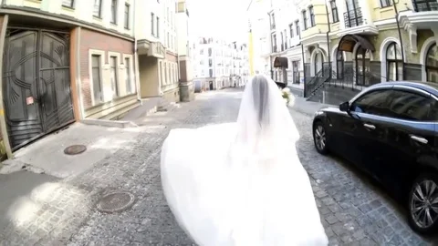 Happy bride with flowers runs down the street Stock Footage 76273864