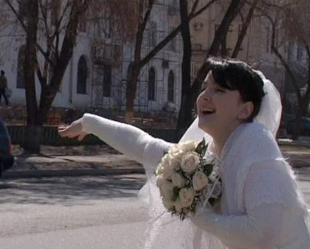 Happy bride waving down stands on street of city Stock Footage 705534
