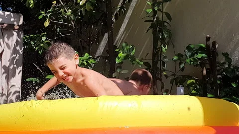 Happy brother laugh and playing in a swimming pool Stock Footage 134543853