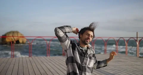 Happy brunette guy with a shield in a checkered shirt relaxes and does yoga on Stock Footage 291947756