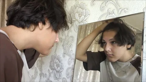 Happy brunette young man combing smooth straight hair 스톡 동영상 313182989