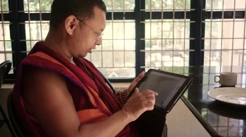 Happy Buddhist Monk going through photos in tablet Stock Footage 60198529