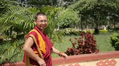 Happy Buddhist Monk walking through park Stock Footage 60202160