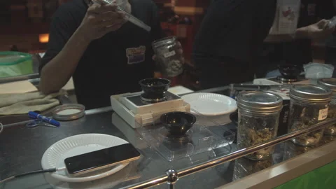 A Happy bud's staff holds up a piece of cannabis. Stock Footage 201212932