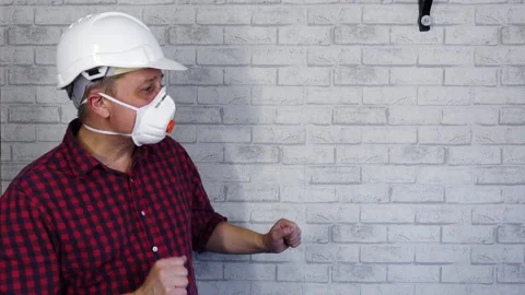 A happy builder on the background of a brick wall is dancing Stock Footage 169059143