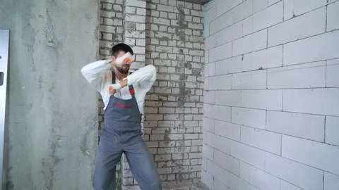 Happy builder dancing and having fun at construction site with free space Stock Footage 102889063