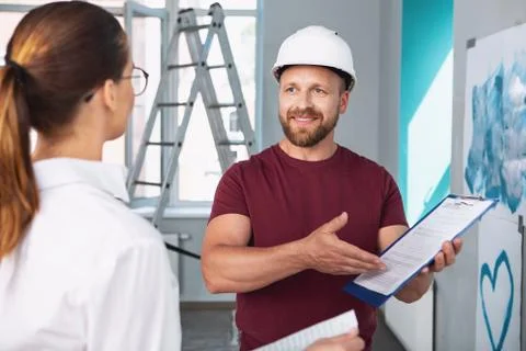 Happy builder showing the contract to his client Stock Photos
