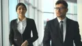 The happy businessman and a businesswoman walking in the office. slow motion HD Footage