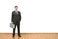 The happy businessman with a case standing on the white wall background Photo