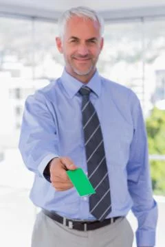 Happy businessman giving green business card Stock Photos