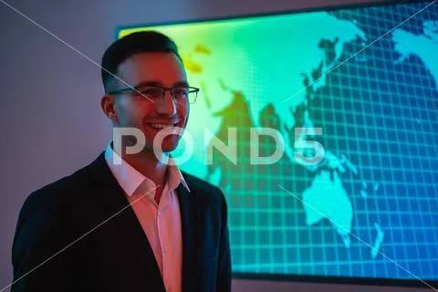 The happy businessman in glasses standing near big display Stock Photos