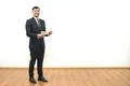 The happy businessman holding papers on the white wall background Photo