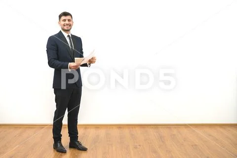 The happy businessman holding papers on the white wall background Stock Photos