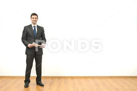 The happy businessman holds papers on the white wall background Stock Photos