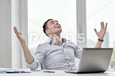 Happy businessman with laptop in office Stock Photos