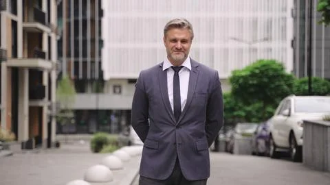 Happy businessman posing outdoors while holding arms crossed. Slow motion Stock Photos