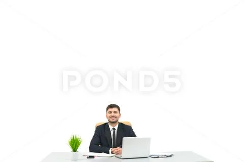 The happy businessman sitting at the desktop on the white background Stock Photos