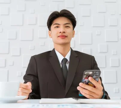 Happy businessman smile while using his mobile phone to check on social media Stock Photos