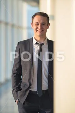 The happy businessman stand near the column Stock Photos