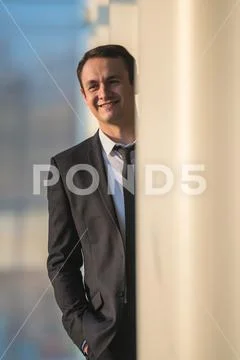 The happy businessman stand over the column in the business center Stock Photos